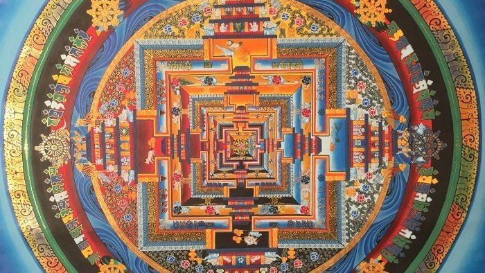 Mandala coloré et complexe avec des motifs géométriques et des symboles.