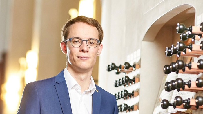 Yngre mand blå jakke ved orgel