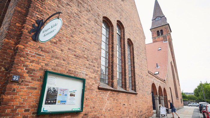Røde mursten og tårn, skilt og billedskrin på bygning