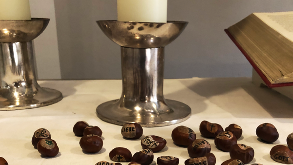 Kastanien mit Worten wie 'Liebe' und 'Segen' auf dem Altar.