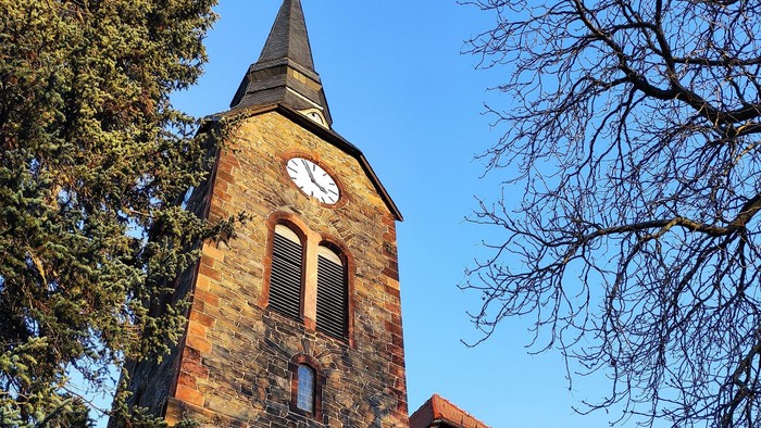 Gotische Kirche mit hohem Turm und Uhr.