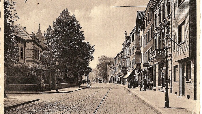 Vintage-Straßenszene in Düsseldorf mit historischen Gebäuden, Straßenbahnschienen und Architektur aus dem frühen 20. Jahrhundert.