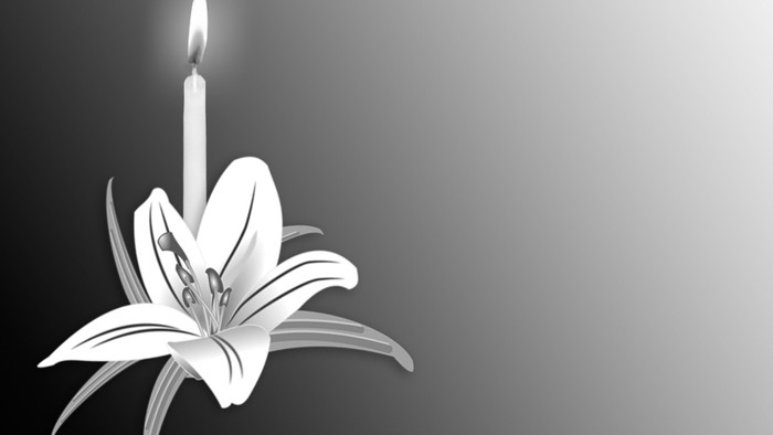 Kerze mit Blume in schwarz-weiß. Trauersymbol.