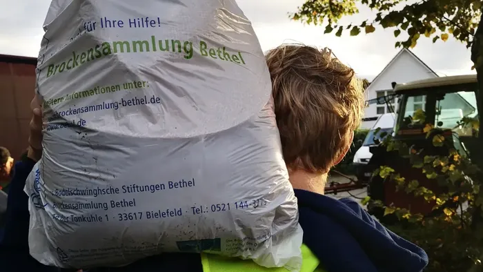 Jugendmitarbeiter trägt Sack zur Bethel- Kleidersammlung