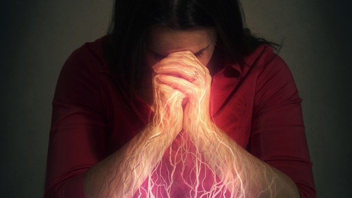 Eine Person in tiefer Kontemplation, aus deren Händen leuchtende Energie über ein offenes Buch strömt.