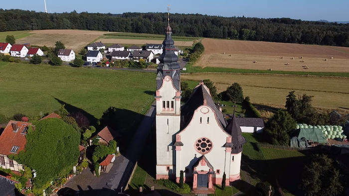 Kirchliche Dorfansicht mit Kirche und Feldern