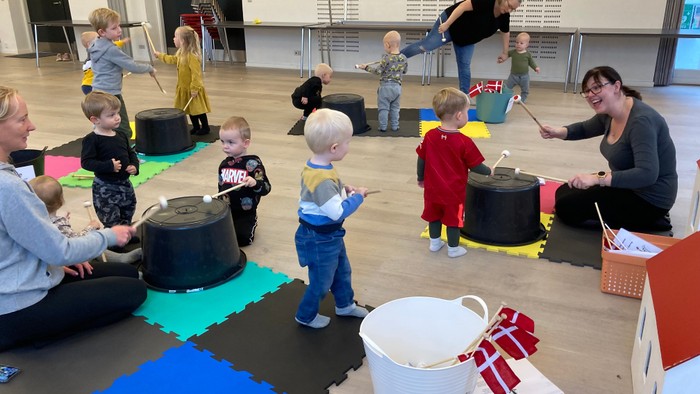 Børn og voksne spiller med musik i legerum