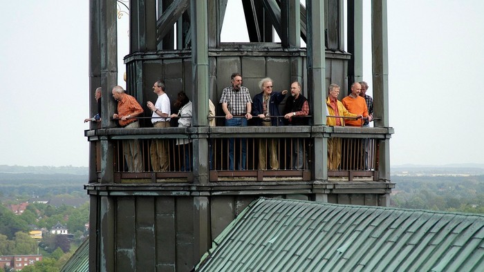 Einige Personen stehen auf einer Aussichtsplattform eines Turms.