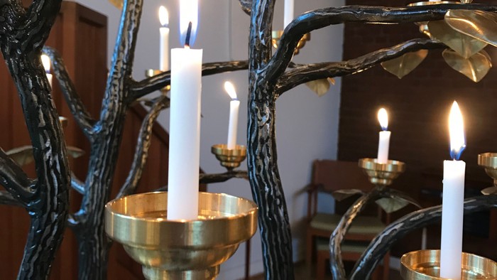 Guldfarvede kandlely med blomster og bladformede lygter
