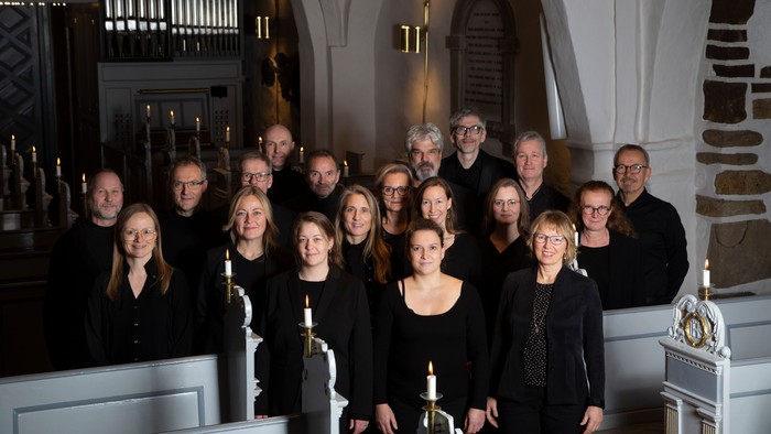 En gruppe af mænd og kvinder poserer sammen i en kirke.