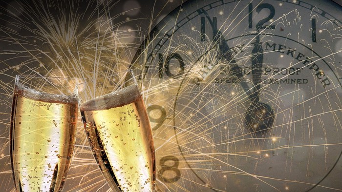 Toast med champagnoglober og nyårsfyrværkeri foran klokke.