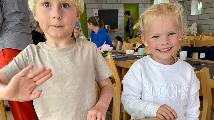 To børn holder stolt et skilt med klemmer og ting fra naturen.