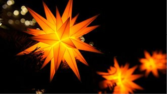 Leuchtende orangefarbene Sterne vor dunklem Hintergrund