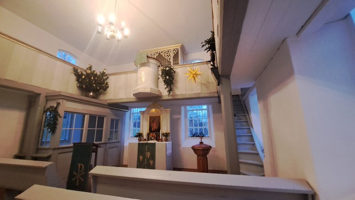 Innenraum einer Kirche mit Altar, Kanzel und Weihnachtsdekoration