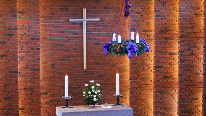 Alter i kirke med lysestake og blomsterarrangement