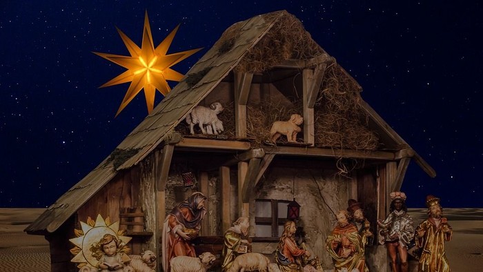 En julekreds med Jesusbarnet, Maria, Josef og dyr i en hytte under stjernen.