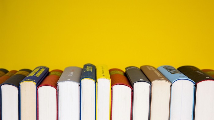 Eine Reihe von Büchern vor einem gelben Hintergrund