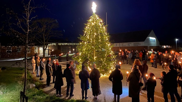 En juletræ og en folkemasse med lysekøn.