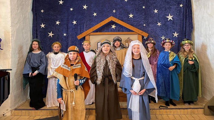 En gruppe skuespillere i juleopførelse forestiller nativity-scenen