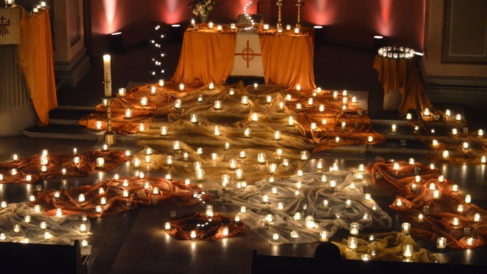 Viele Kerzen und Lichterketten in einer Kirche