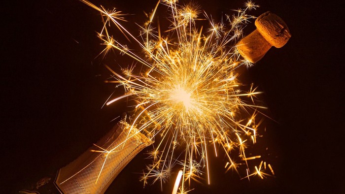 Feierliche Knallbonbons sprühen golden in der Dunkelheit