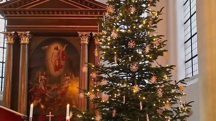 Kircheninneres mit Weihnachtsbaum und Altar.