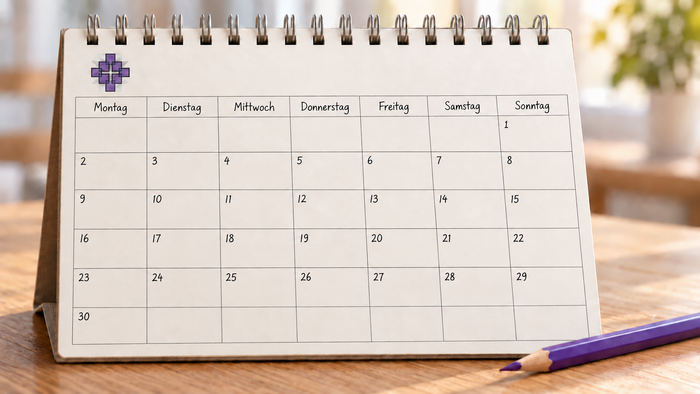 Ein Stehpult-Planer mit einem deutschen Kalender und einem violetten Bleistift daneben.