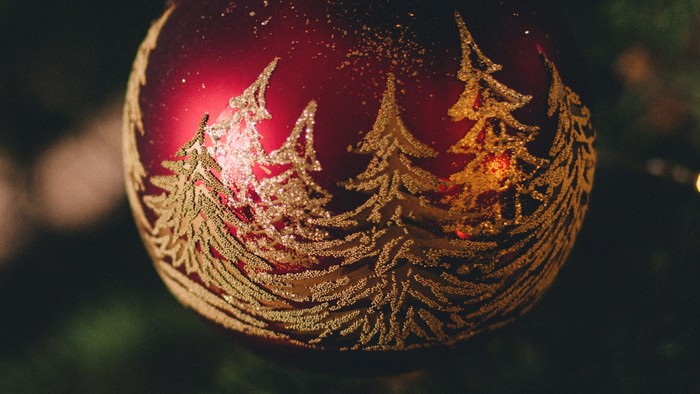 En juletree med røde glitrende pynt og lys.