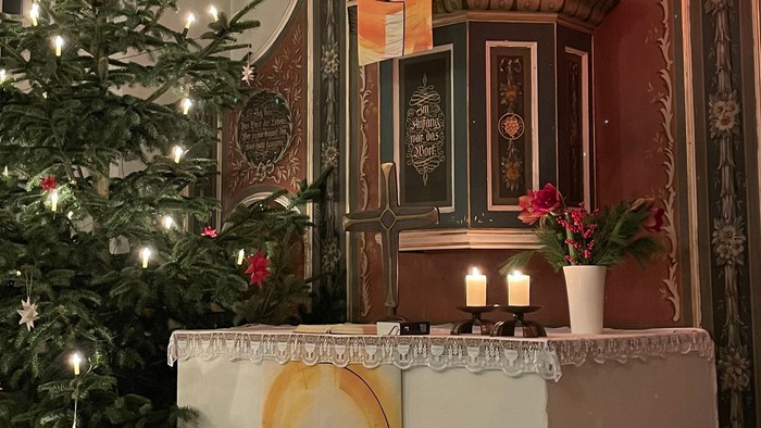 Weihnachtsdekoration in Kirche mit Christbaum und Krippenbild