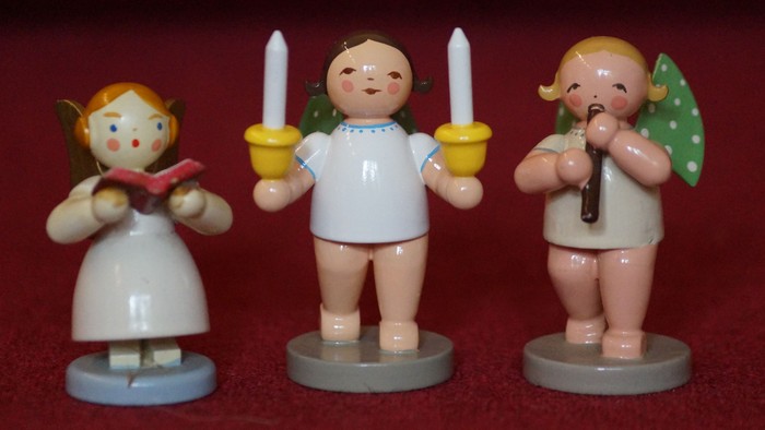 Drei kleine Engelfiguren mit Kerzen und Blättern