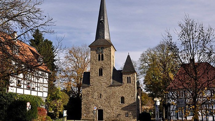 Das Bild zeigt die Dorfkirche in Wengern mit inmitten von Fachwerkhäusern.