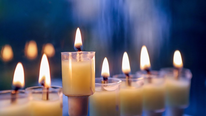 Ni tændte lys arrangeret i en traditionel menorah med en blødt sløret baggrund.