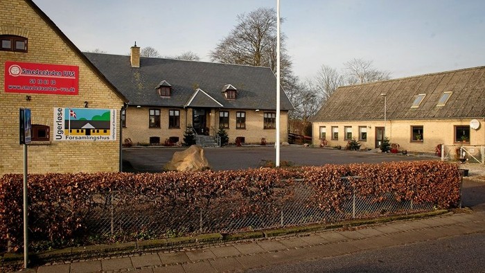 En hyggelig landsby-forsamlingshus med skiltning for lokale tjenester og et indhegnet haveområde.