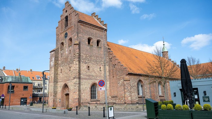 Gamle kirke med teglmur og spistegning i bymiljø