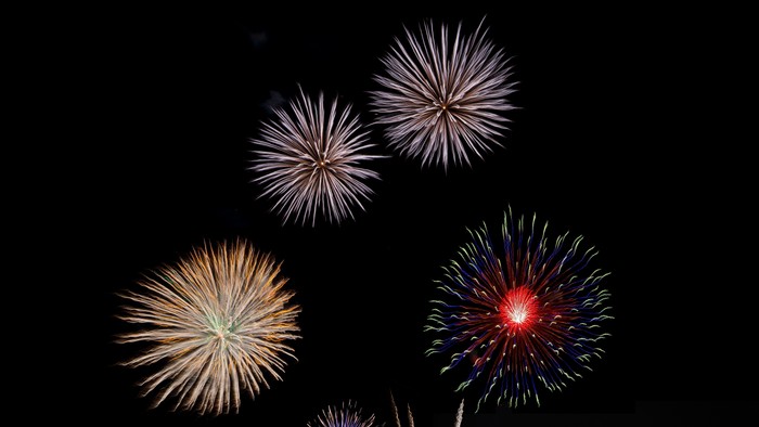 Bunte Laternen und Feuerwerk am dunklen Himmel
