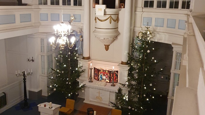 Großer Raum mit zwei Weihnachtsbäumen und grosser Uhr