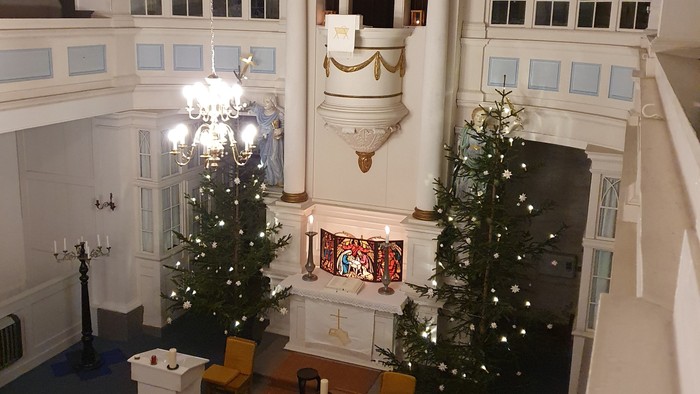 Großer Raum mit zwei Weihnachtsbäumen und grosser Uhr