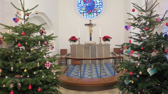 To altar i kirken er pyntet med julenisser og lys.