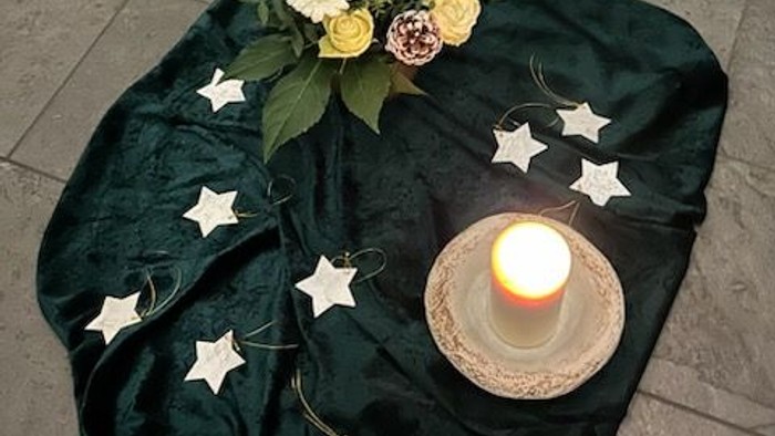 Kerze, Blumen, Sterne auf einem Tuch