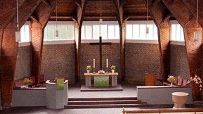 Innenraum einer Kirche mit Holzstühlen und hohem Gewölbe