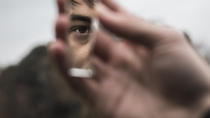 Person hält Handy vor Gesicht, unscharfes Bild
