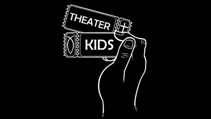Eine Hand hält ein weißes „Theater Kids“-Ticket vor einem dunklen Hintergrund.