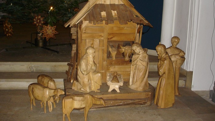 Handgeschnitzte Holz-Krippe mit der Darstellung der Geburt Jesu, Tieren und Figuren.