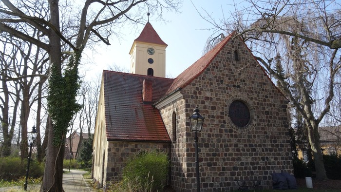 Kirchengelände mit Uhrturm und altem Steinbau