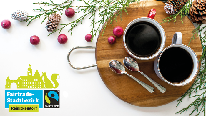 Zwei Tassen Kaffee mit Weihnachtsdekoration und Fairtrade-Logo