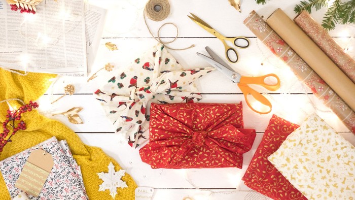 Bunte Bastelutensilien für festliches Verpacken und Geschenkeschmücken arrangiert.