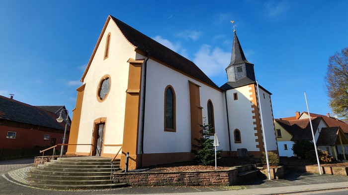 Kleine Kirche mit Turm und Treppe vorne, sonniger Tag