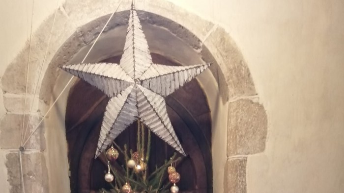 Christmas tree with star topper in stone building.