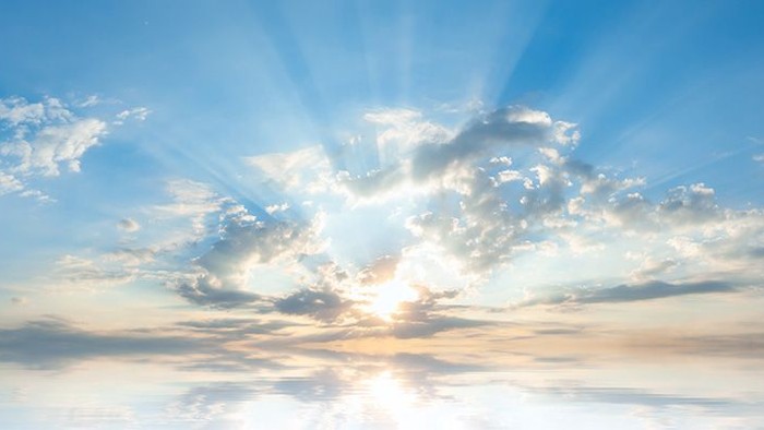 Sunset with radiant light beams through scattered clouds