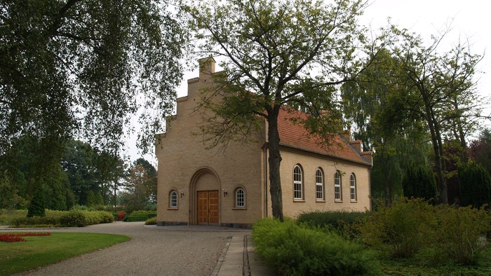 En lille kirke med smukke vinduer og træer i forgrunden